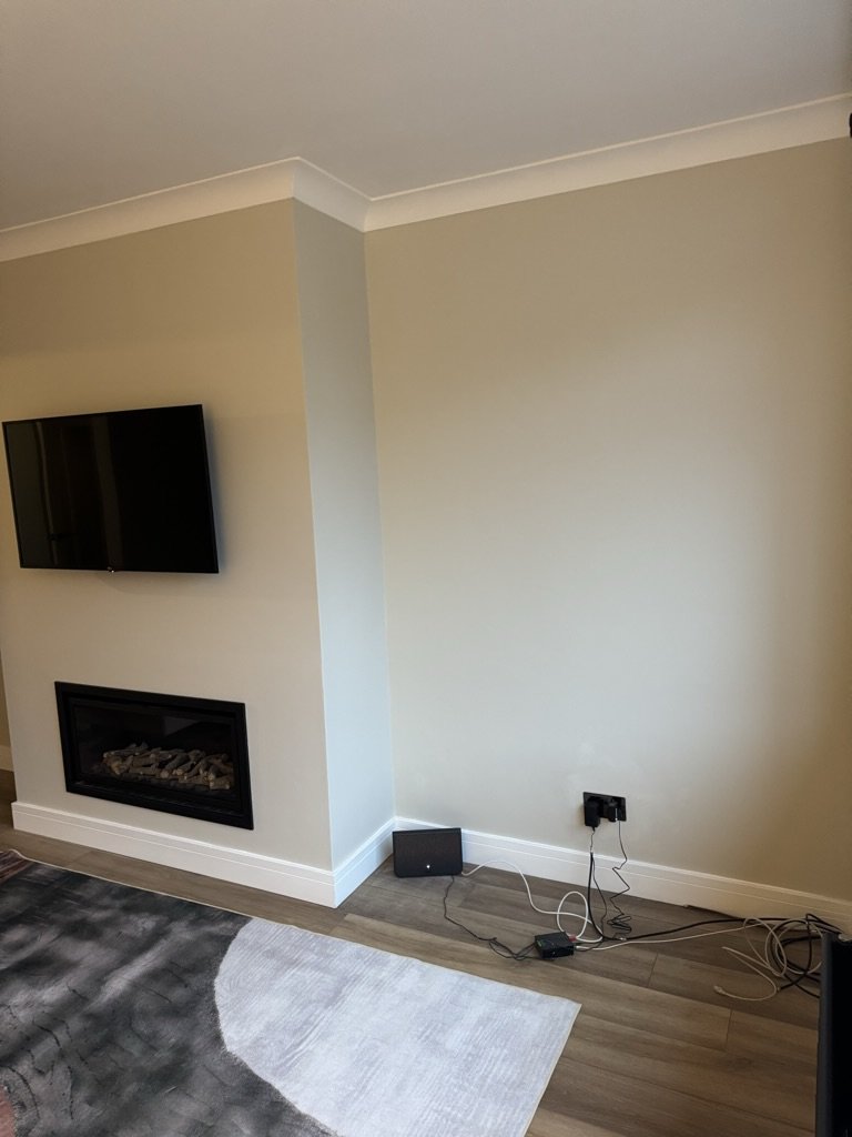 Finished living room after an Aberdeen home renovation, wall-mounted TV, gas fire in a chimney breast alcove, engineered wood floor