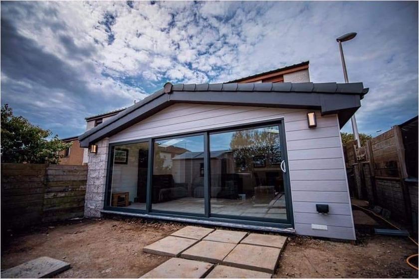 Contemporary cladded rear extension with a granite corner post and full-height corner glazing, Aberdeen