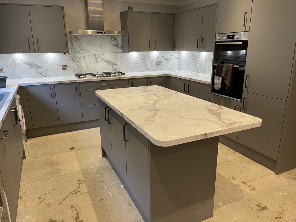 Bright fitted kitchen with island and oven illustrating the design and installation service across Aberdeenshire