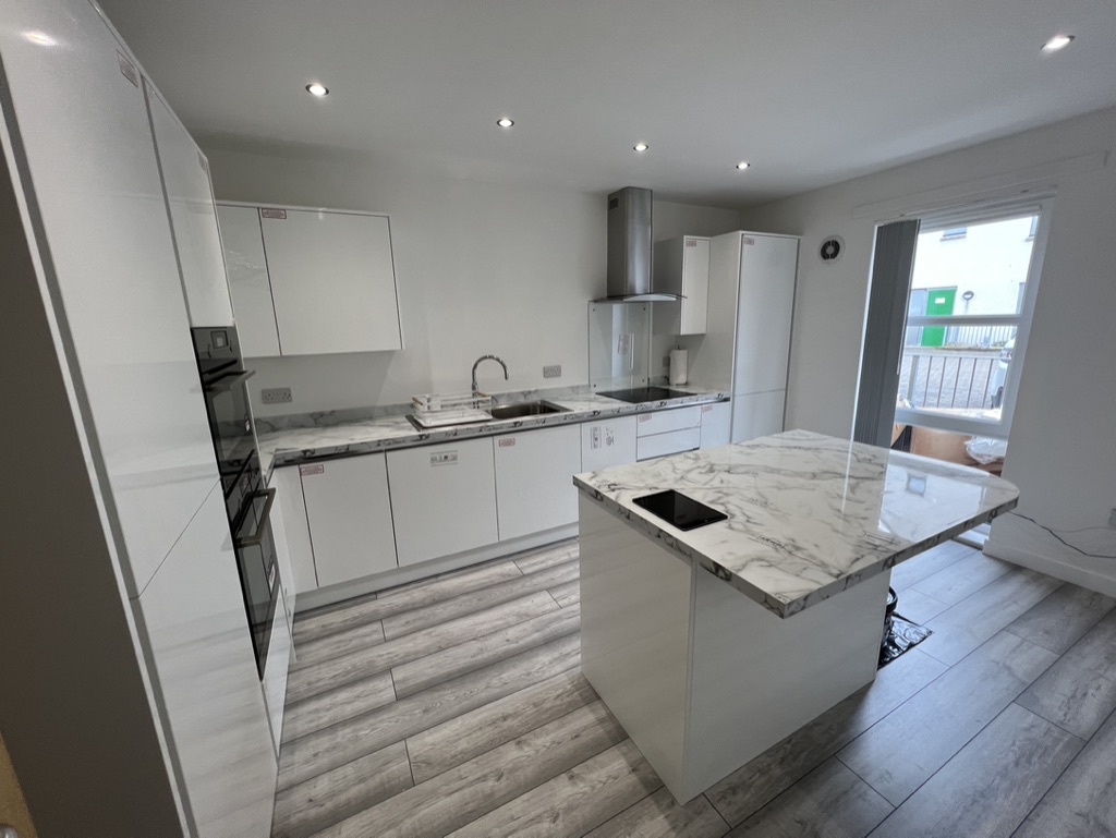 Light-filled kitchen opening to the garden through patio doors in Bridge of Don