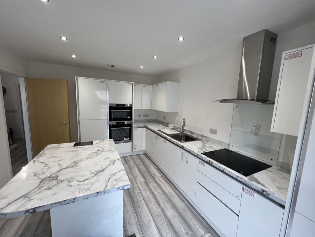 Kitchen renovation in a Bridge of Don home with a large marble-effect island and white handleless cabinetry