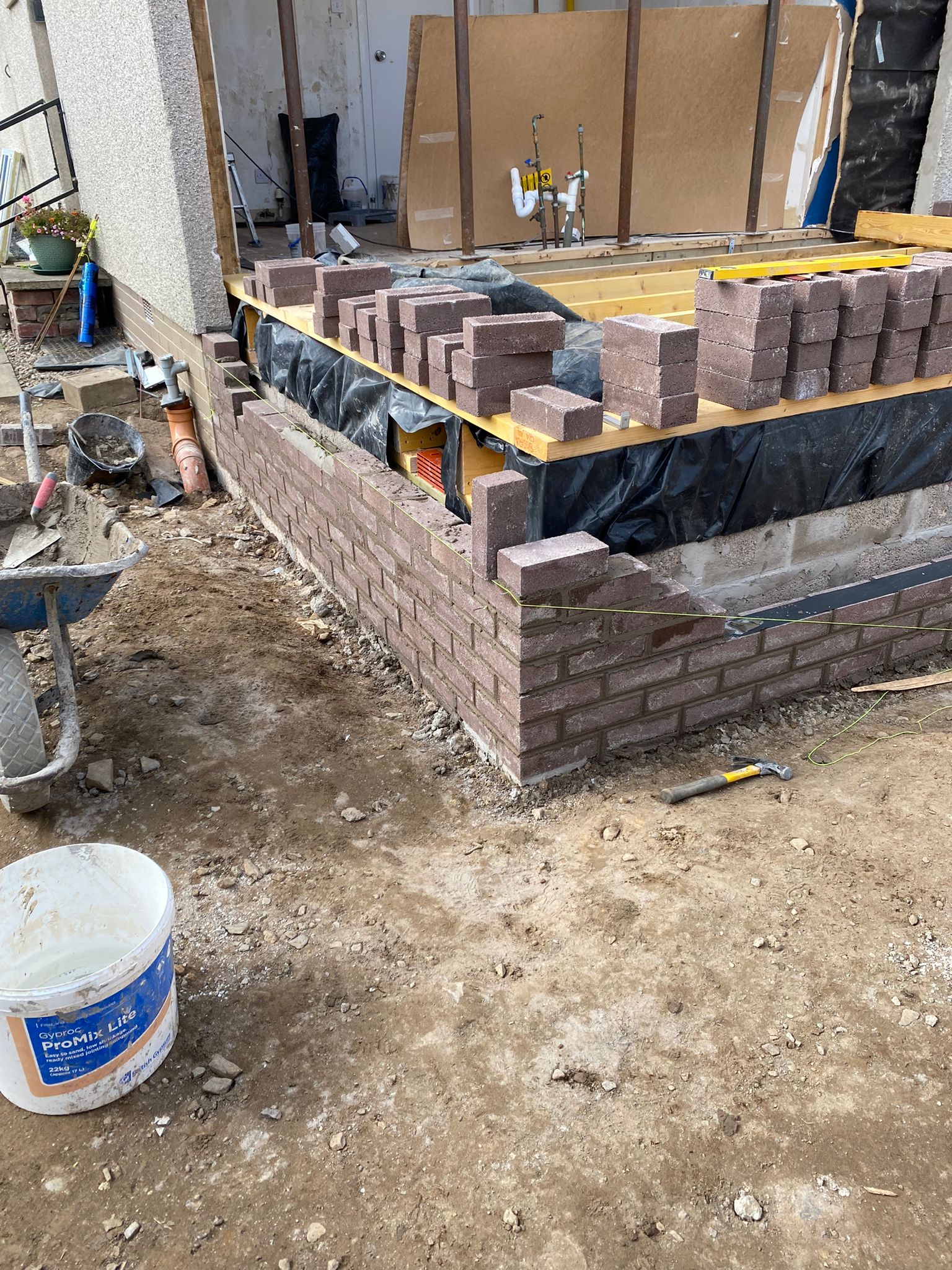Extension under construction with blockwork outer skin, damp proof membrane and timber floor joists