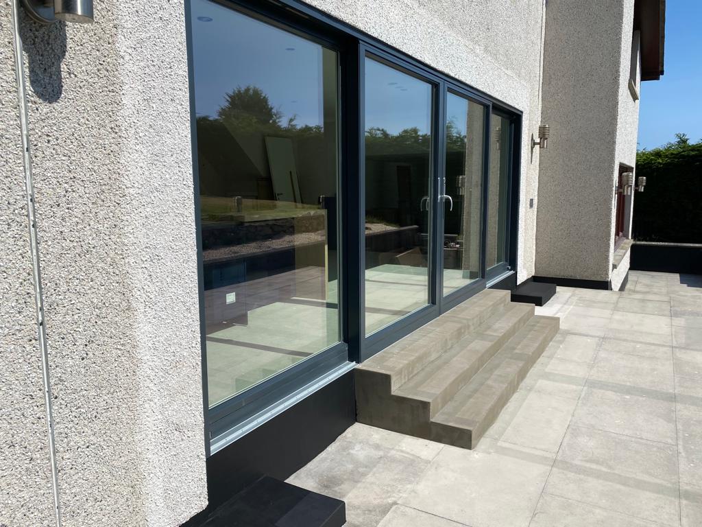 Completed extension exterior with anthracite sliding doors and new paving